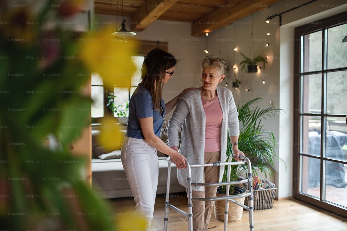 A caregiver helping a senior woman walk comfortably at home
